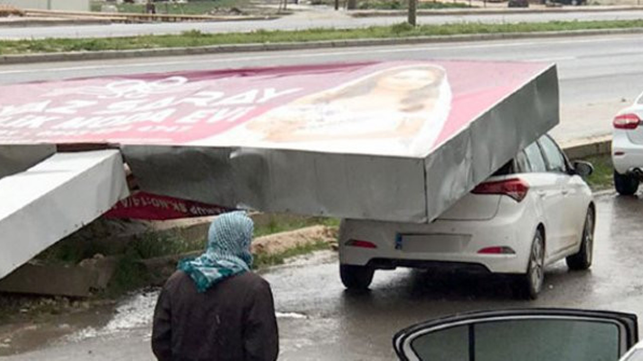 Reklam tabelası, fırtınada otomobilin üzerine devrildi
