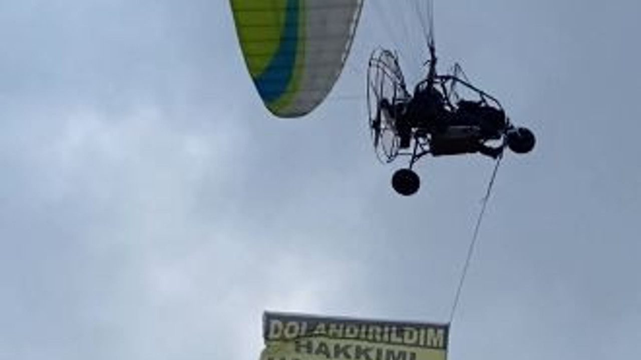 Kiraladığı paramotorla 'dolandırıldım, hakkımı arıyorum' yazılı afişle uçtu