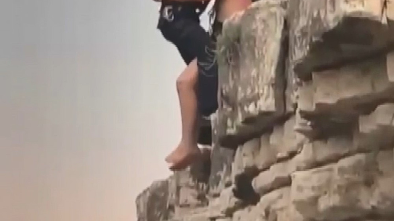 Denize atlamak için çıktığı kayada mahsur kaldı