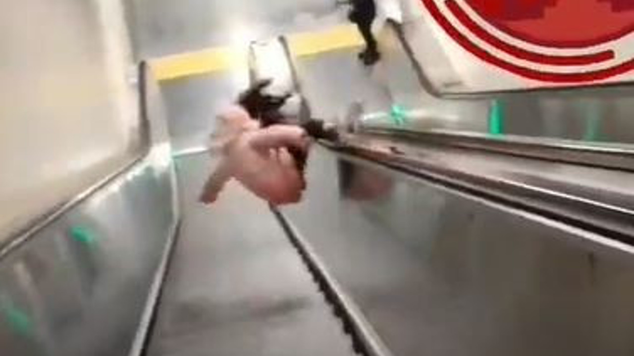 Yürüyen merdivenden kayan küçük çocuk taklalar atarak uçtu