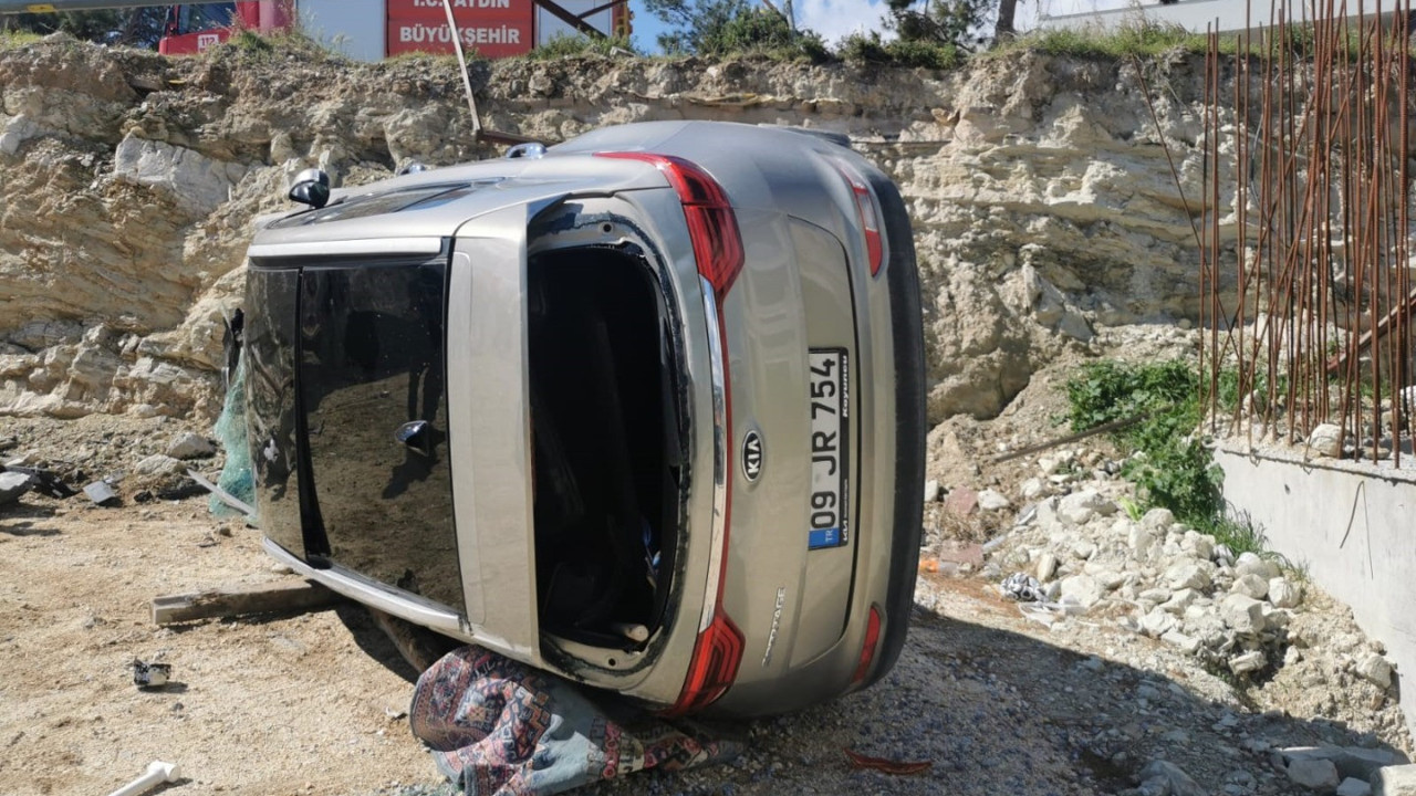 Yoldan çıkan lüks araç inşaat alanına devrildi