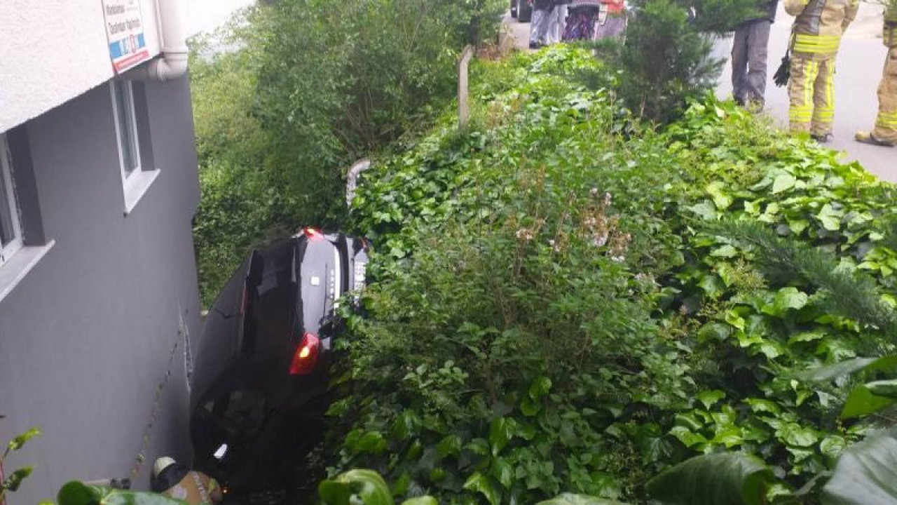 Otomobil 3 katlı binanın bahçesine düştü