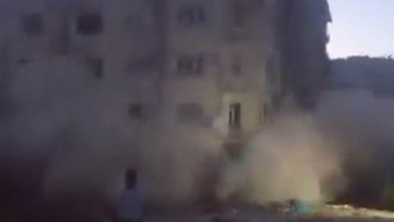 Depremlerde ağır hasar gören binayı taş atarak yıktı