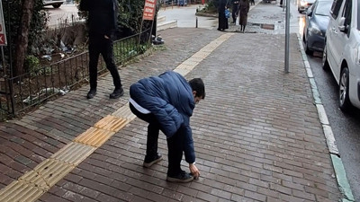 Tepki alınca geri dönüp yere attığı çöpleri topladı