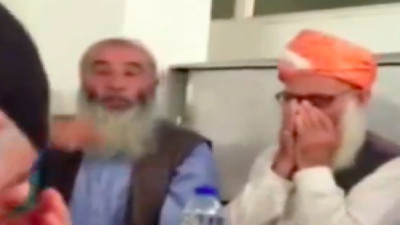 Menzil Cemaati'nin şeyhini anlatan adamın abartılı övgüleri ve yanındaki adamın garip sesleri