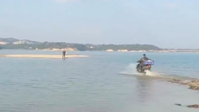 Adana'da kuryeler hizmette sınır tanımıyor. Siparişi teslim etmek için motorla göle girdi