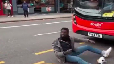 Bir sığınmacı akan trafiği yolun ortasında otobüsün önüne yatıp engelledi