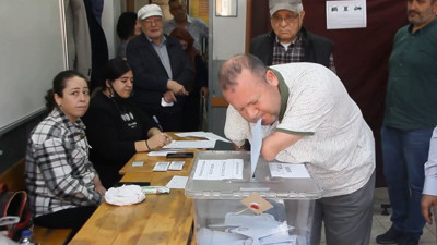 Oy zarfını ağzıyla sandığa attı
