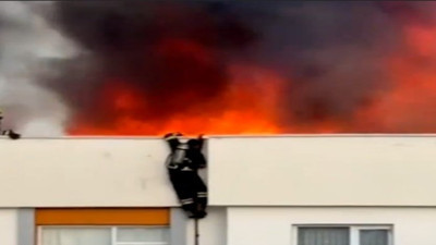 Alevlerin arasında mahsur kalan itfaiye eri hortumla aşağıya inmeye çalışırken düştü