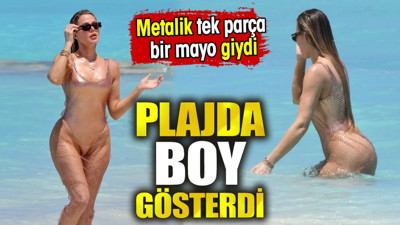 Plajda boy gösterdi. Metalik tek parça bir mayo giydi