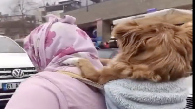 Hayvansever kadın sıkılan köpeğini bebek gibi sırtında taşıyarak gezdirdi
