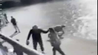 Tuttuğu balıkları geri bırakmasını isteyen kadını denize attı