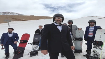 Takım elbise, kravat ve papyonla snowboard yaptılar