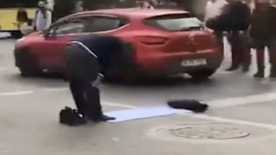 Yolun ortasında trafiğe aldırmadan namaz kıldı