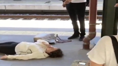 Ritüel dedi istasyonda insanlara aldırmadan boylu boyunca yere uzandı