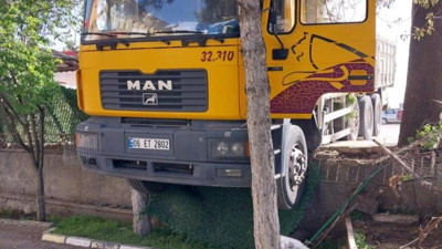 Yol hakimiyetini kaybeden kamyon duvarda asılı kaldı
