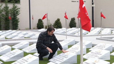 Güvenlik görevlisi şehit mezarlarının bakımlarını yapıyor