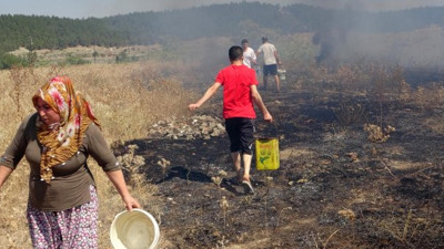 Otluk alandaki yangını vatandaş söndürdü: Kova kova su taşıdılar