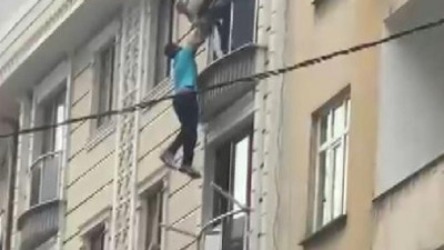 Pencereden sarkarak intihar girişiminde bulunan kişiyi dakikalarca tutup kurtarmaya çalıştılar