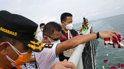 Endonezya'da düşen yolcu uçağında hayatını kaybedenler için denize çiçekler bırakıldı