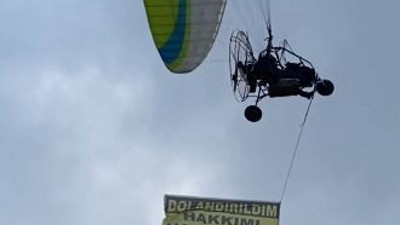 Kiraladığı paramotorla 'dolandırıldım, hakkımı arıyorum' yazılı afişle uçtu