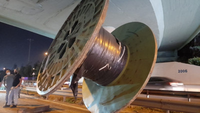 Tırın üstündeki dev makara köprüye takılarak yola düştü