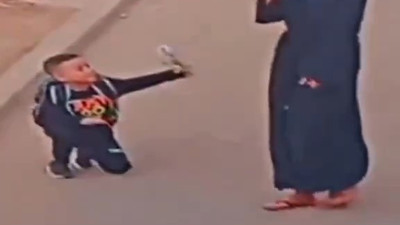 Küçük çocuk ayakkabısını bağlayan annesine sokağın ortasında sürpriz yaptı. Annesi elleriyle yüzünü kapattı