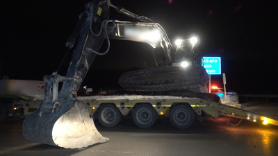 Tırın taşıdığı iş makinesi yola devrildi