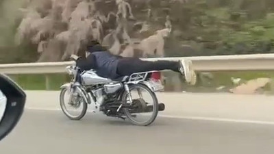 Canını hiçe saydı motosikleti üzerine uzanarak kullandı