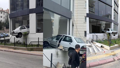 Kaldırıma çarpıp havalanan otomobil binada asılı kaldı