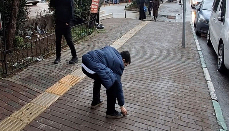 Tepki alınca geri dönüp yere attığı çöpleri topladı