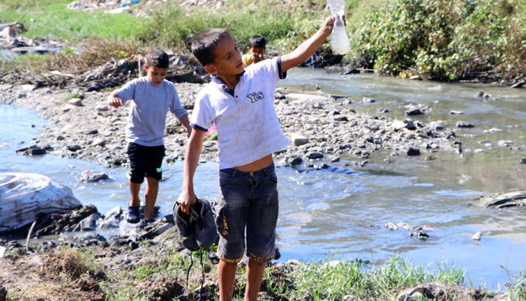 Adana’da çocuklar oyun diye lağım suyunun aktığı derede kurbağa avlıyor