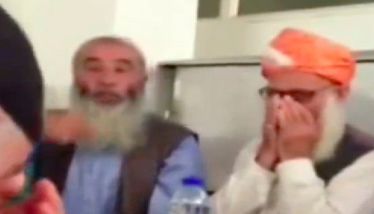 Menzil Cemaati'nin şeyhini anlatan adamın abartılı övgüleri ve yanındaki adamın garip sesleri