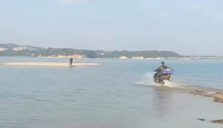 Adana'da kuryeler hizmette sınır tanımıyor. Siparişi teslim etmek için motorla göle girdi