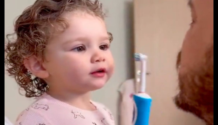 Sevimli minik, babasının dişlerini fırçalamasına yardım ederken mutluluktan kendinden geçti, izleyenleri kendine hayan bıraktı