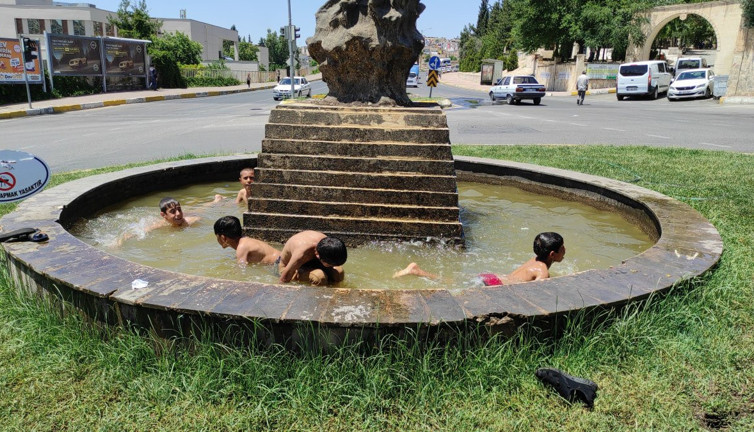 Sıcaktan bunalan çocuklar süs havuzunda serinledi