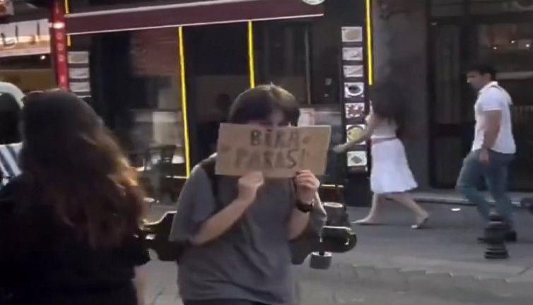 Yoldan geçenlerden bira parası isteyen genç sosyal medyada gündem oldu