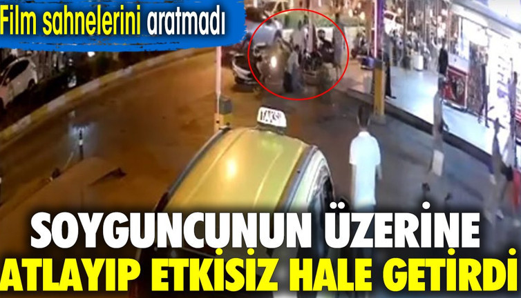 Soyguncunun üzerine atlayıp etkisiz hale getirdi. O anlar kamerada