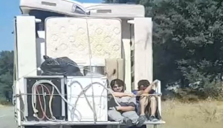 Eşya yüklü kamyonetin arkasında iki kişi taşıdılar