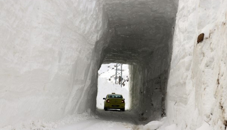 Çığ düşen köy yolunda karı kaldıramayınca tünel açtılar