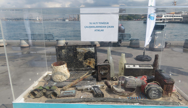 Şişelerin içerisinde canlı balık var. Denizden çıkanları sergilediler vatandaş biz pazarı sandı. Kalaşnikoftan motosiklete, sazdan kelepçeye neler var neler