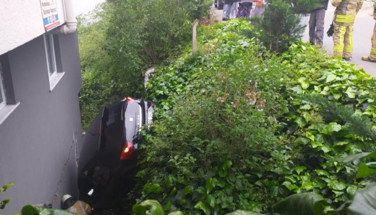 Otomobil 3 katlı binanın bahçesine düştü